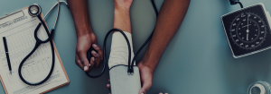 A medical professional checking the pulse rate, using a stethoscope.