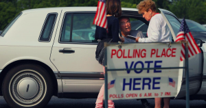 An image of two polling officers assisting a person with disabilities to access curbside voting.