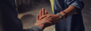Image of one hand assisting another hand.