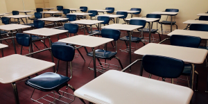 A empty classroom full of desk chairs and tables.