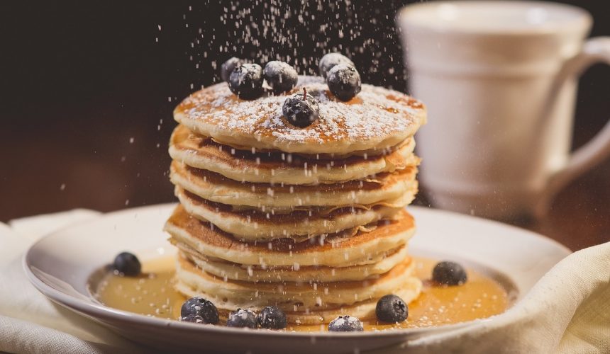 Stack of blueberry pancakes with powdered sugar