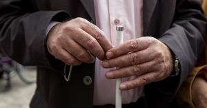 An individual holding a white cane.