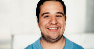 A young man with a developmental disability smiling.