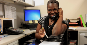 Christie on the phone while working at her desk.