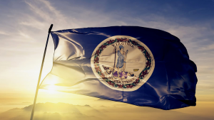 The sun setting behind the state flag of Virginia.