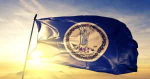 The sun setting behind the state flag of Virginia.