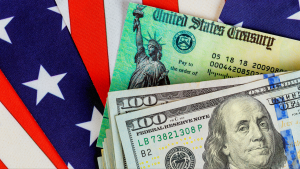 Two one hundred dollar bills placed on top of a fake Social Security check.