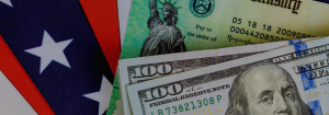 Two one hundred dollar bills placed on top of a fake Social Security check.