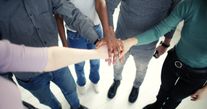 Diverse colleagues stacking hands together