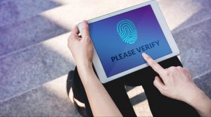 Verification Access for Security System Concept, Woman using Tablet with Fingerprint Scanning Technology in Outdoor