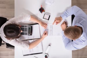 wo Businesspeople Analyzing Bill