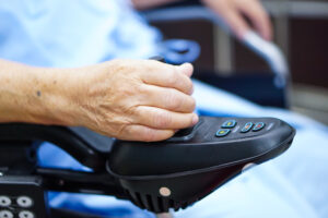 Asian senior or elderly old lady woman patient on electric wheelchair with remote control at nursing hospital ward