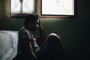 Young man feeling depressed and stressed in the dark room,