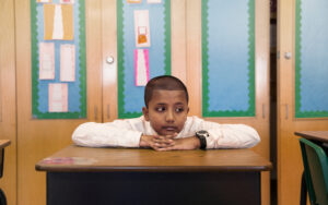 School student (8-9) sitting at desk