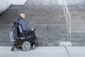 Disabled man on an electric wheelchair who can't get up the stairs