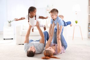 Happy interracial family playing on floor
