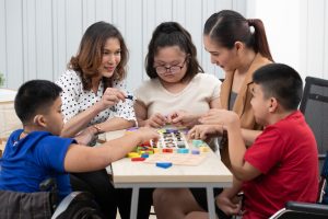 Group of special students in classroom, a down syndrome girl
