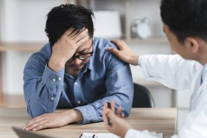 Doctor or psychiatrist shakes hands encouragement the patient and care having a consultation on diagnostic examination on male disease or mental illness in a clinic or hospital mental health service