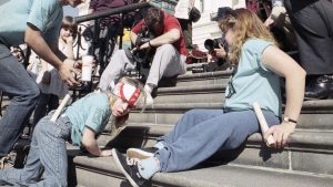 Image of several disabled protestors, including 8-year-old Jennifer Keelan, crawling up the capitol steps.
